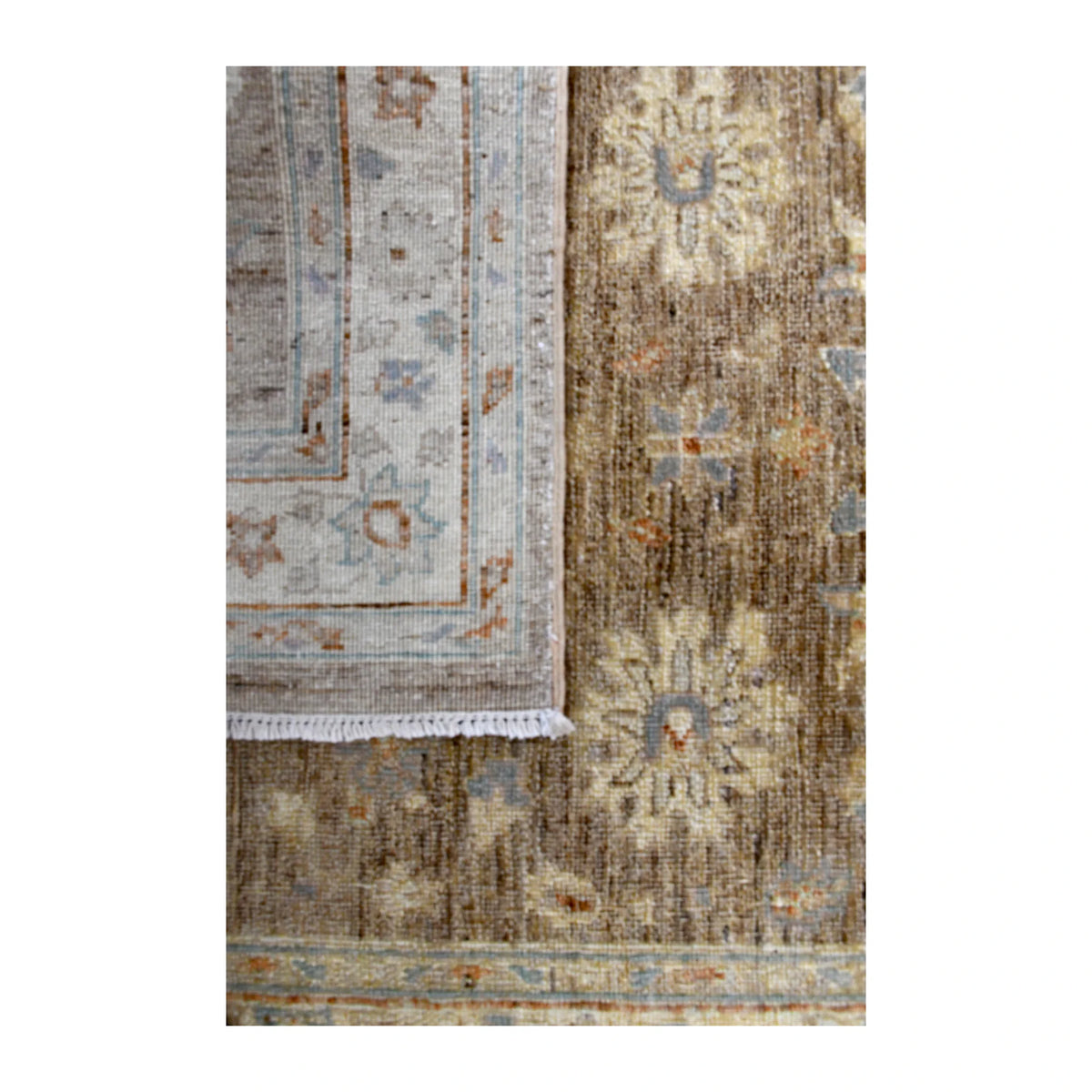 Folded-corner detail of Afghan Chobi runner showing the patterned reverse beside its taupe floral front and pale border