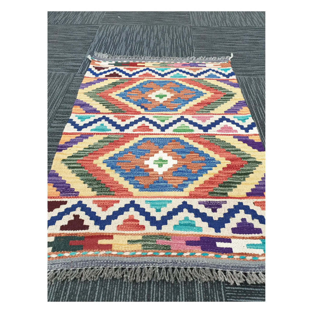 Angled view of Afghan Chobi Kilim flatweave rug showing geometric double diamond pattern, 85 x 60 cm
