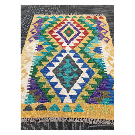 Angled view of Afghan Chobi Kilim flatweave rug showing elongated twin diamond motif, 85 x 65 cm