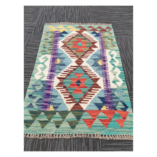 Angled view of Afghan Chobi Kilim rug showing twin-diamond motif and fringe, 88 x 59 cm