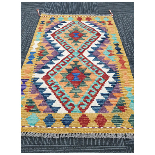 Angled view of small Afghan Chobi Kilim wool rug showing geometric flatweave design, 92 x 60 cm
