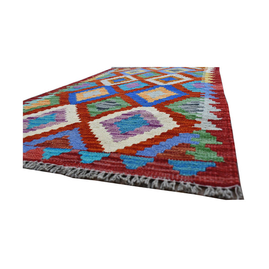 Angled fringe and edge detail of Afghan Chobi Kilim rug showing flatwoven wool texture and bright geometric motifs