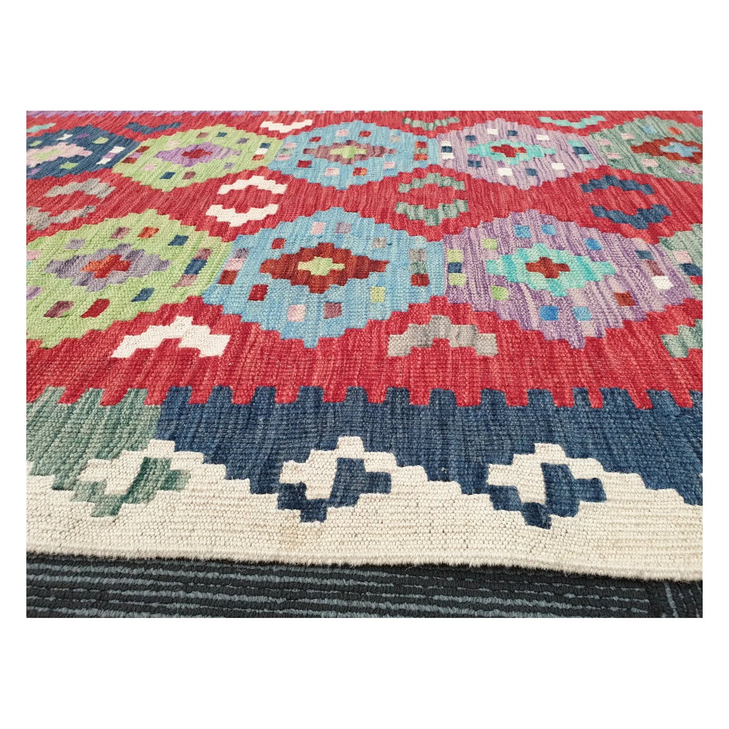 Low-angle close-up of Afghan Chobi Kilim wool flatweave texture and geometric pattern detail, 386 x 79 cm