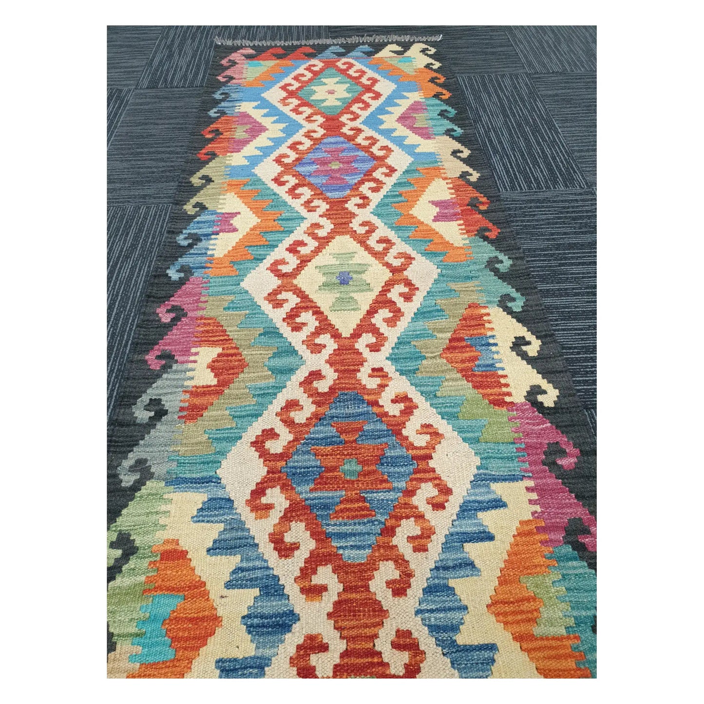 Angled view of Afghan Chobi Kilim runner rug showing elongated linked diamond motif, 194 x 63 cm