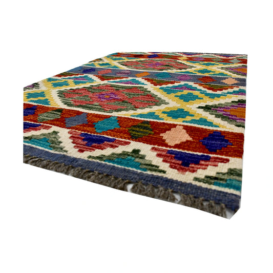 Angled fringe and flatweave detail of Afghan Chobi Kilim wool rug showing teal, rust, ivory and multicolour geometry