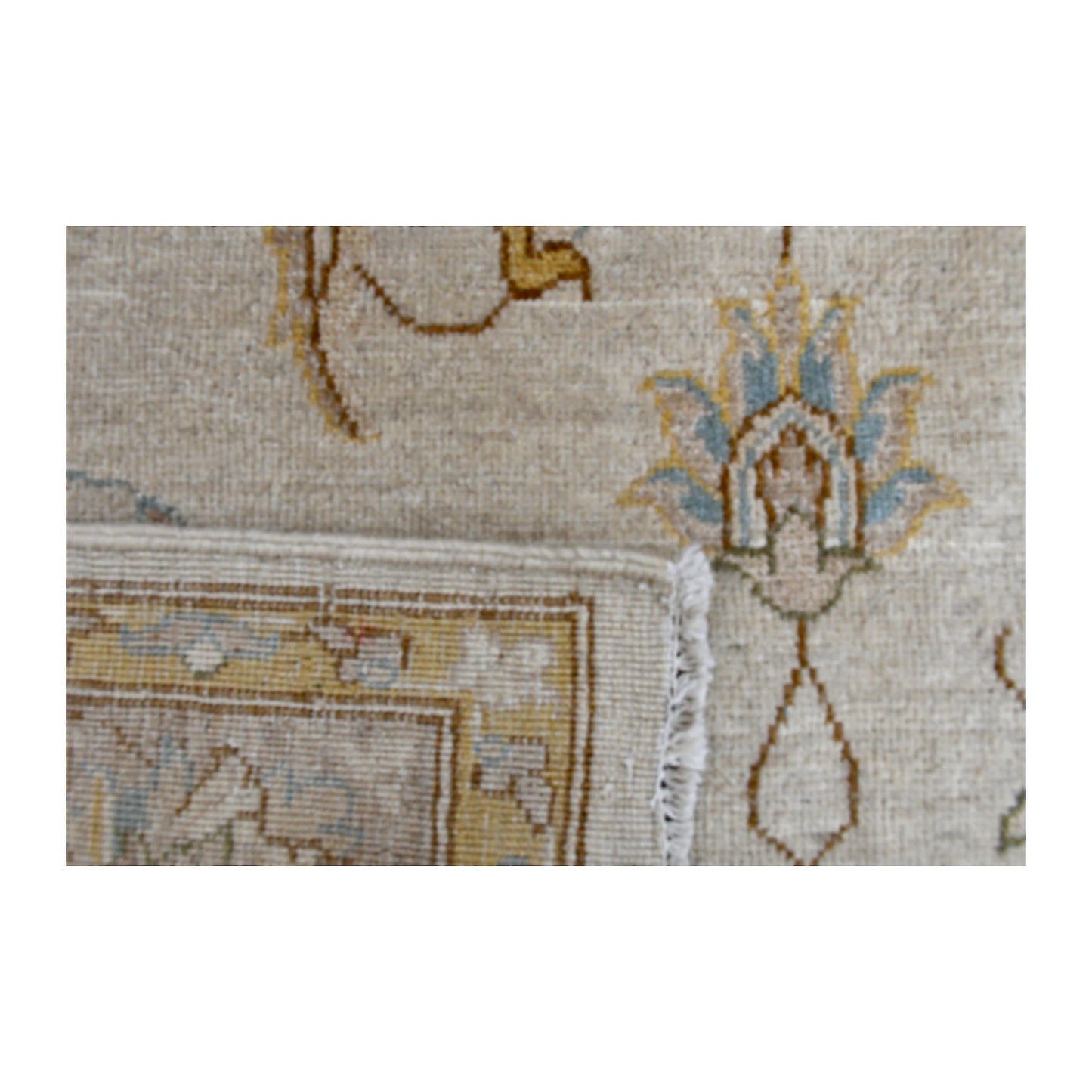 Folded corner detail of Afghan Chobi rug showing the reverse weave, ivory fringe and layered floral border