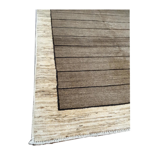 Angled view of Afghan Gabbeh hand-knotted wool rug showing natural wool texture, light brown field and cream border, 166 x 106 cm