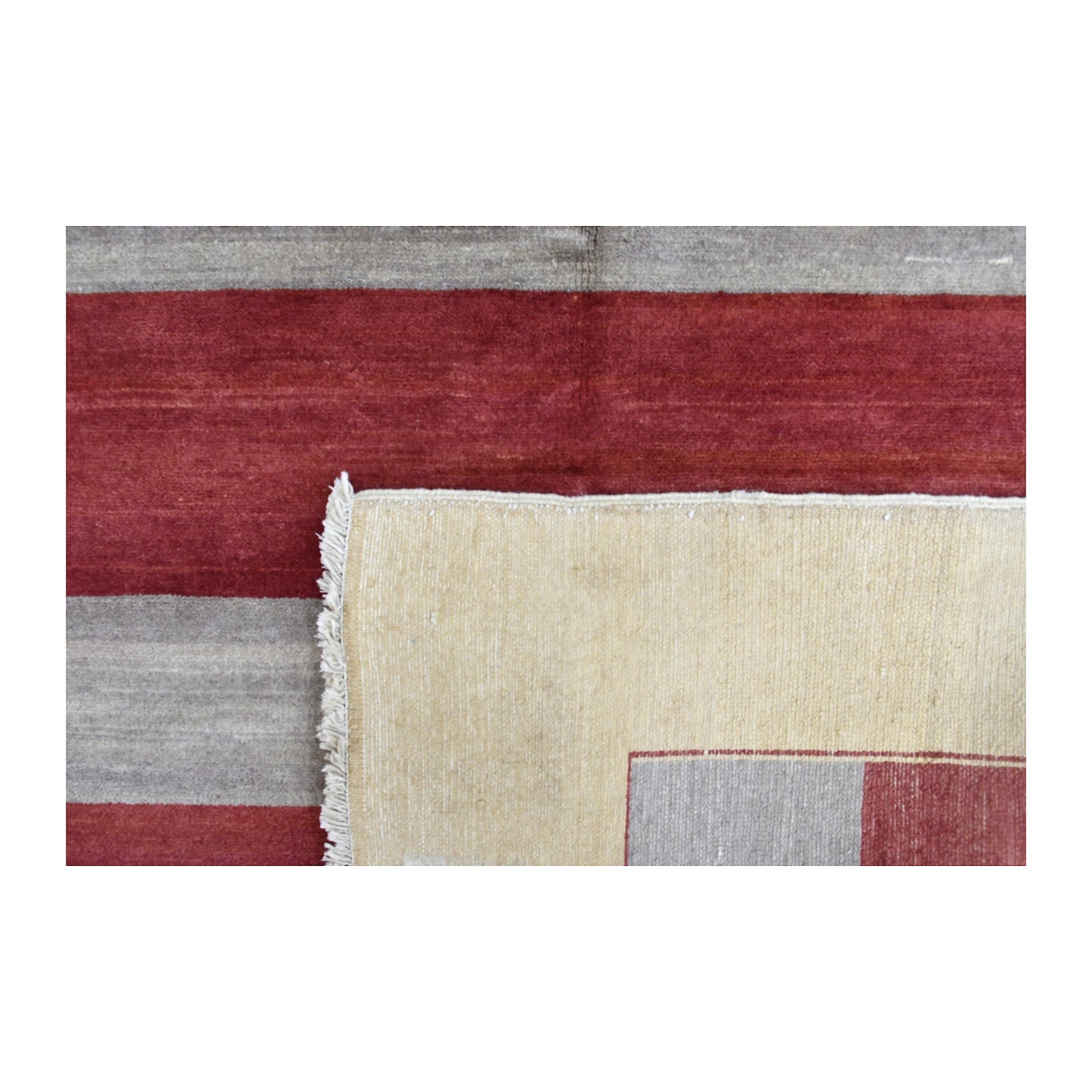 Folded-corner detail of Afghan Gabbeh rug showing the striped front, reverse weave and finished edge
