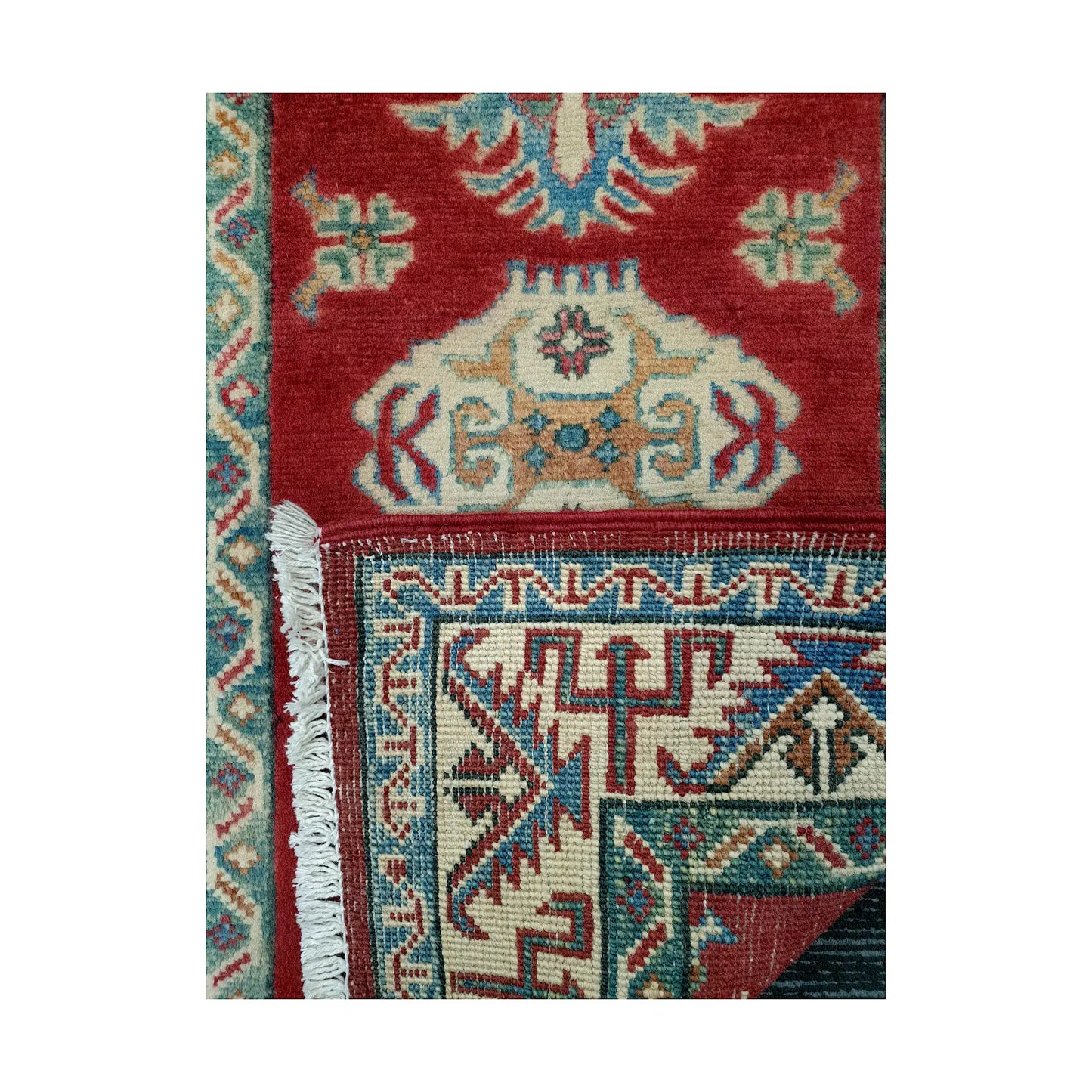 Folded corner reverse-weave detail of Afghan Kazak hand-knotted wool rug showing back structure, border pattern, fringe and red field
