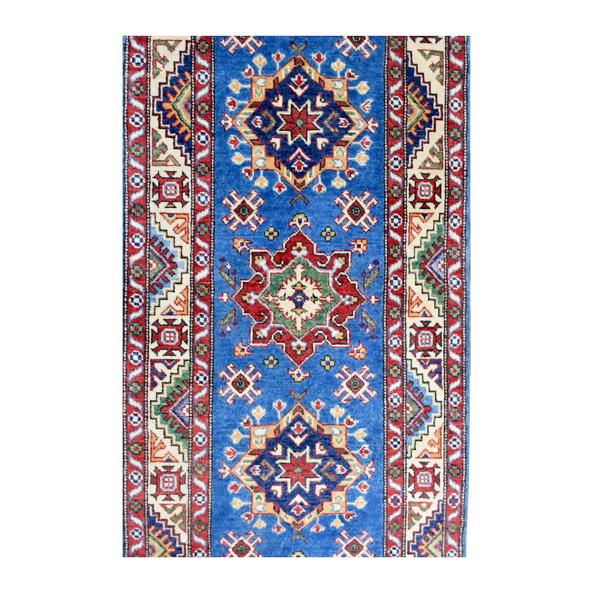 Field detail of Kazak runner showing red and navy medallions, smaller motifs and patterned borders around the blue field