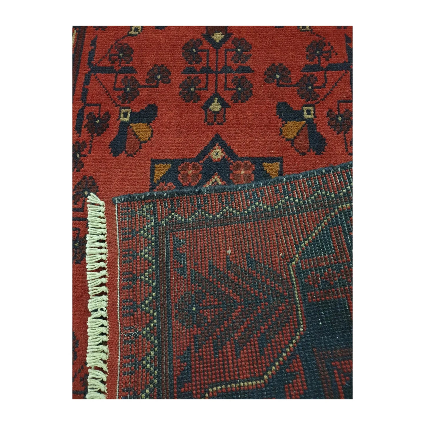 Back corner detail of Afghan Khal Mohammadi hand-knotted wool rug showing folded reverse weave, fringe edge and geometric border structure, 127 x 78 cm