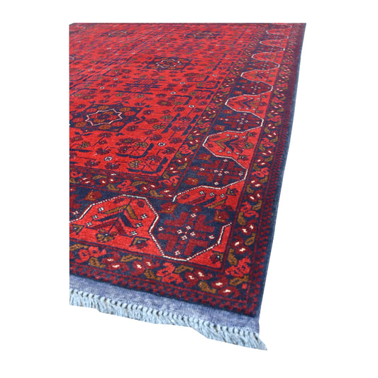 Angled view of Khal Mohammadi wool rug showing its deep red field, geometric motifs, dark borders and pale fringe
