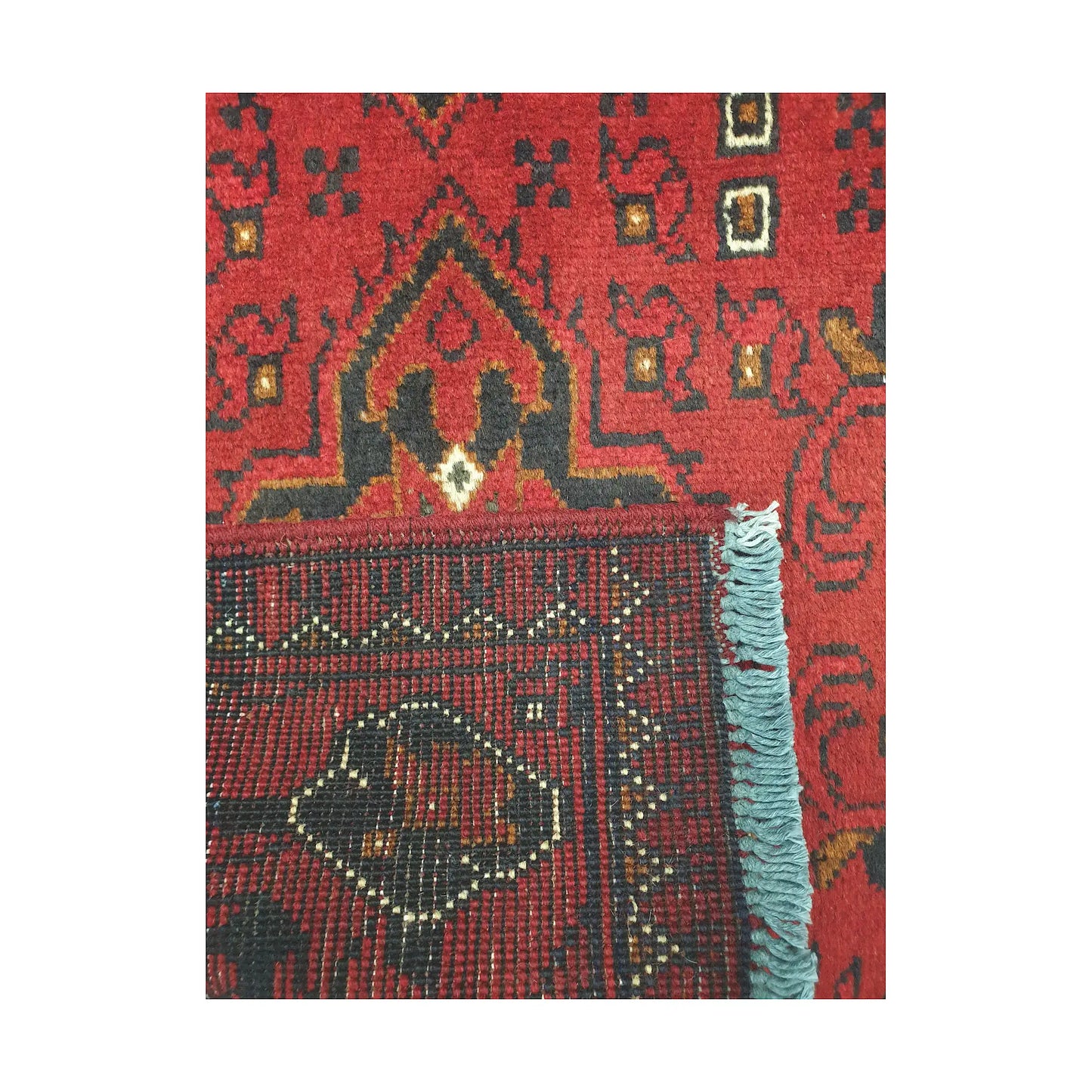 Folded corner reverse-weave detail of Afghan Khal Mohammadi hand-knotted wool rug showing back structure, red field, border pattern and weave