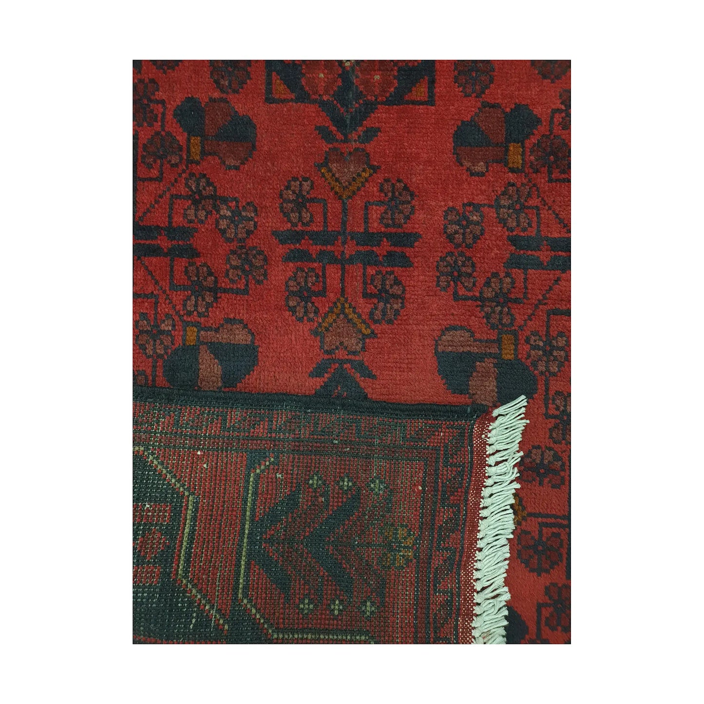 Folded corner detail of Afghan Khal Mohammadi rug showing the back of the rug, fringe and deep red front pattern