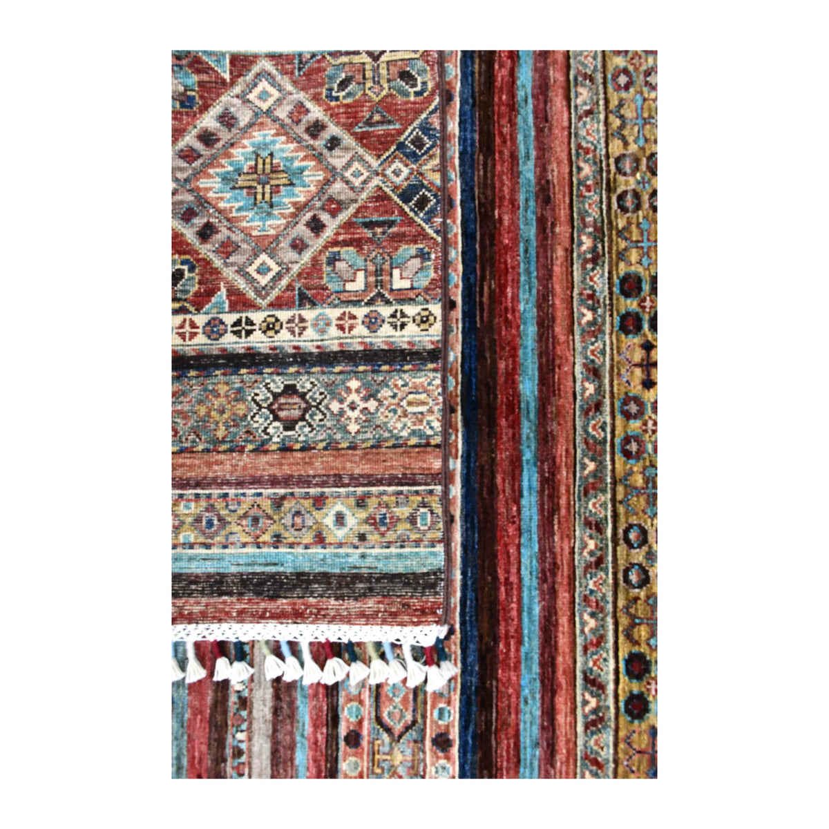 Folded-corner detail of Khurjeen rug showing the reverse weave, patterned front, side border and pale fringe