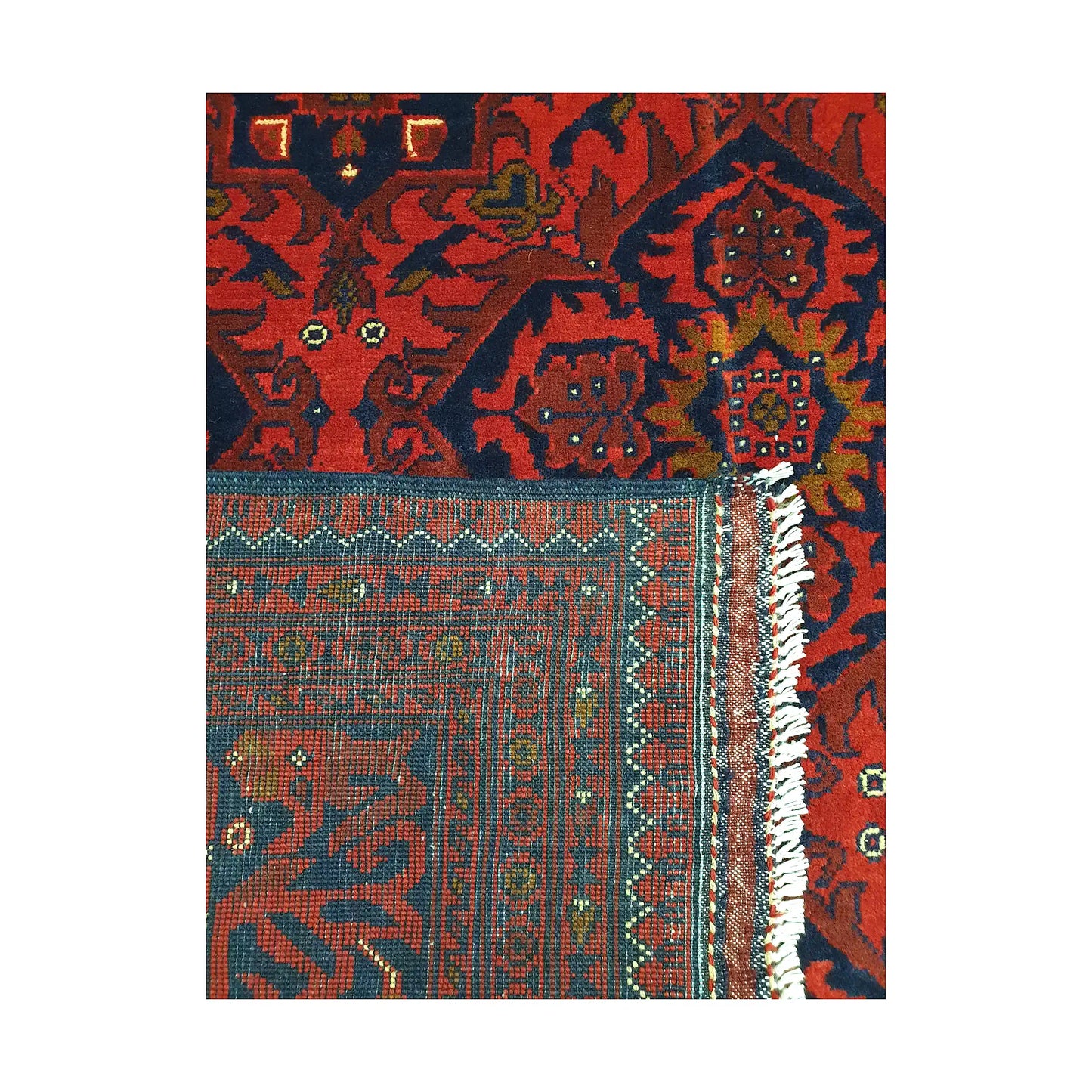 Folded corner detail of Afghan Kunduz rug showing the back of the rug, fringe and deep red front pattern