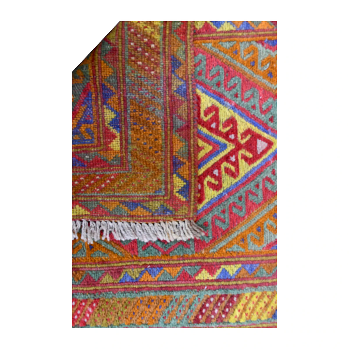 Folded-corner detail of Mashwani runner showing the reverse weave beside its multicoloured geometric front and light-grey fringe