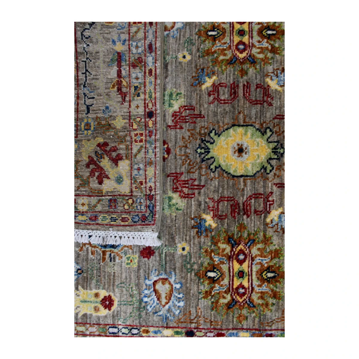 Folded-corner detail of Sultani rug showing the reverse weave beside the multicoloured patterned pile
