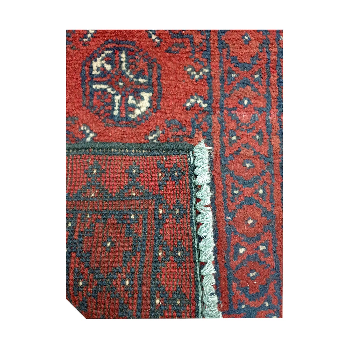 Folded corner detail of Afghan Turkoman red wool rug showing the back, fringe and red front pattern
