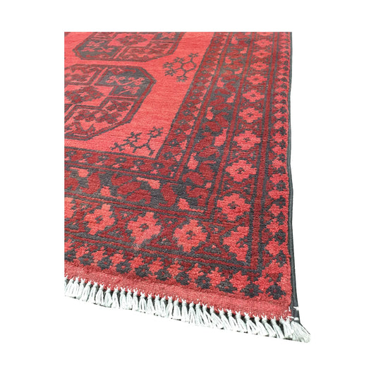 Angled fringe and corner detail of Afghan Turkoman rug showing red wool pile and dark geometric border