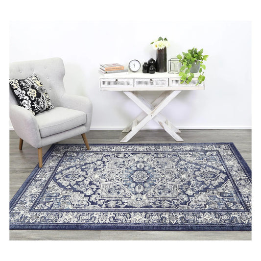 Arya navy rosette traditional rug styled with white furniture in a neutral setting