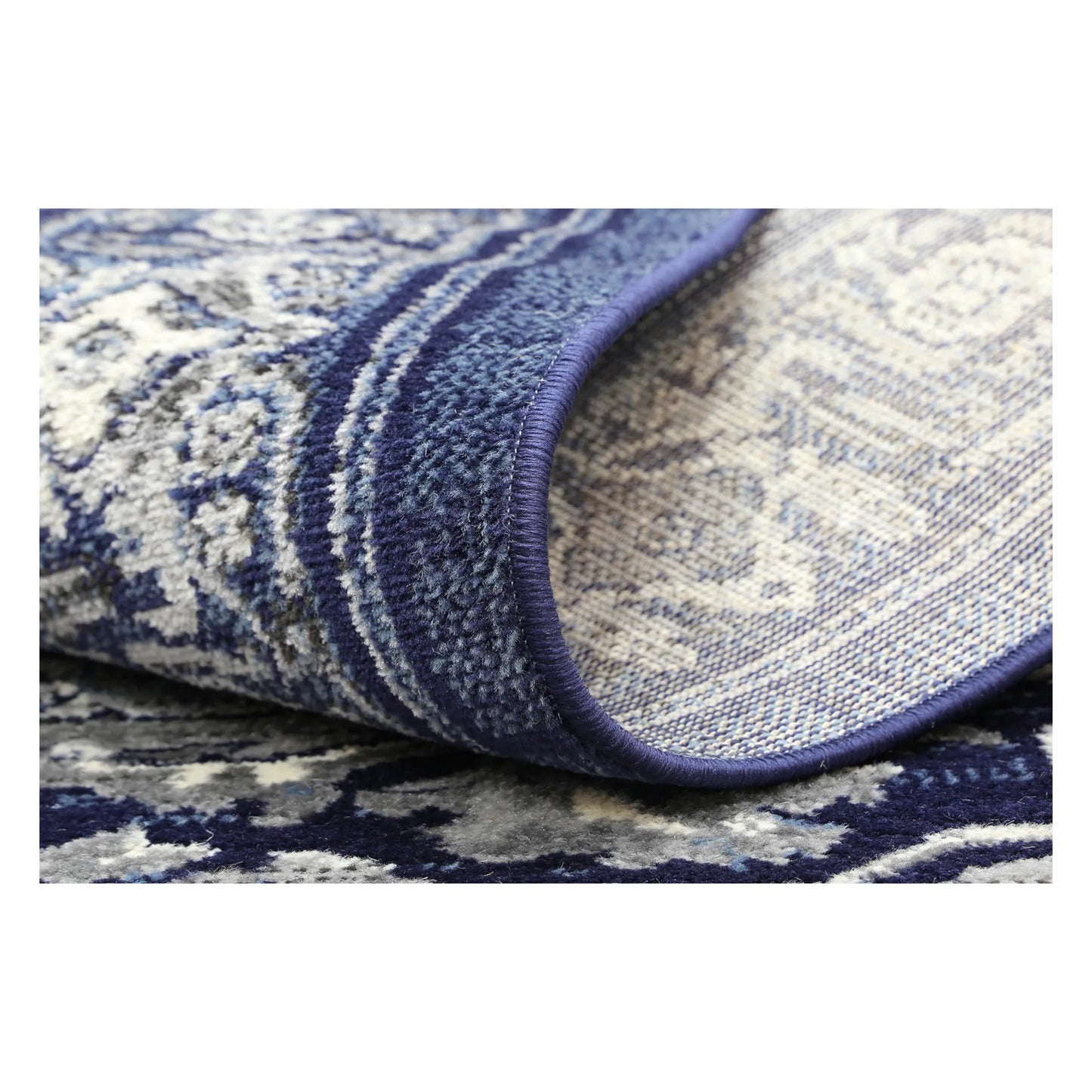 Rolled corner detail of Arya navy traditional rug showing flexible edge and texture