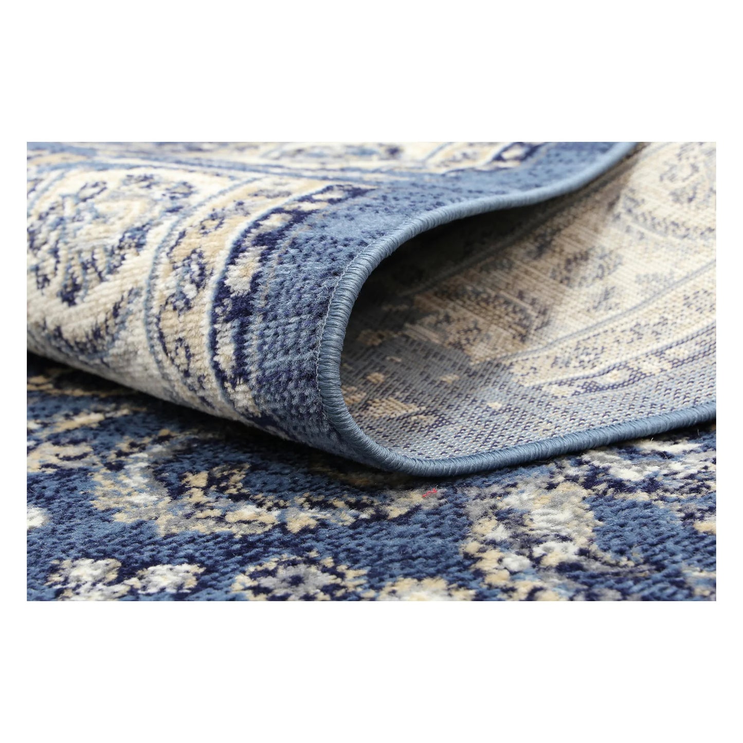 Rolled corner detail of Arya blue traditional floral rug showing flexible edge and texture