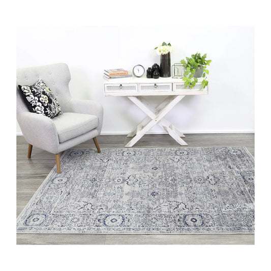 Arya charcoal traditional rug styled with white furniture in a neutral interior setting