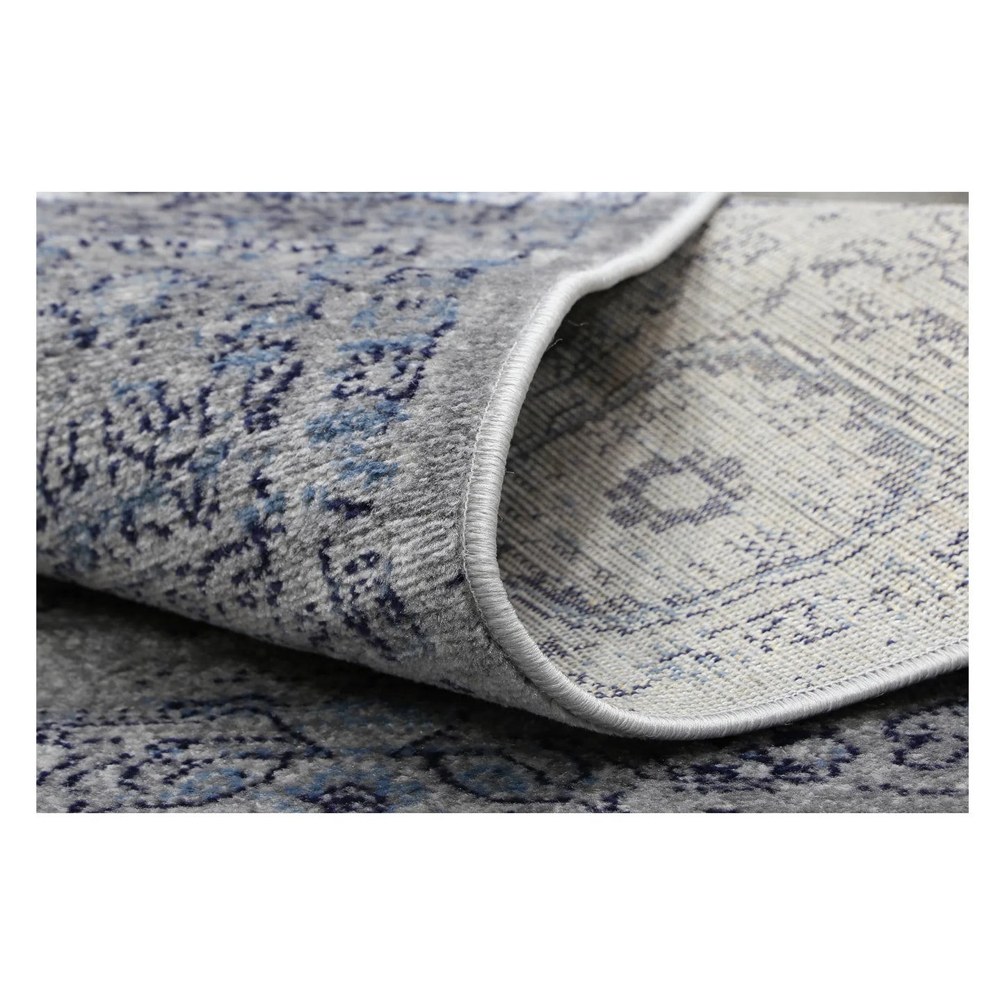 Rolled corner detail of Arya charcoal traditional rug showing flexible edge and texture