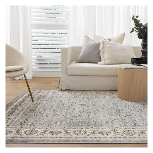Arya grey traditional floral rug styled in a light neutral interior setting
