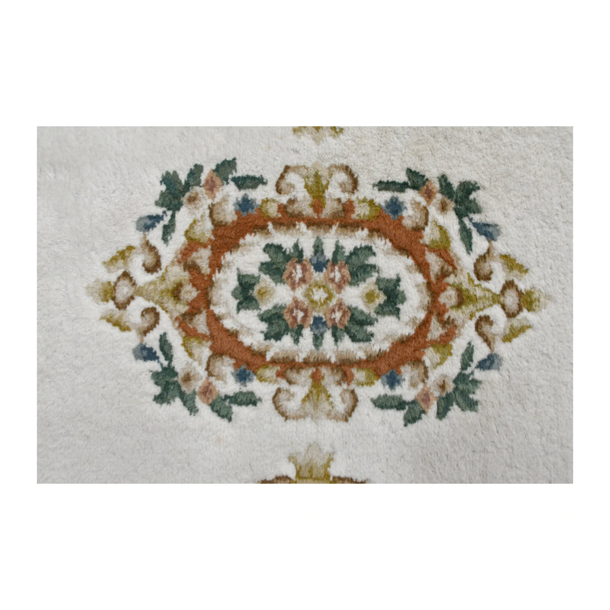 Central medallion detail of Aubusson rug with terracotta, muted green and dusty rose floral motifs
