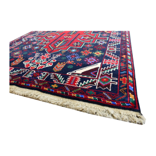 Angled corner detail of Baluchi runner showing the wool pile, patterned side border and ivory fringe