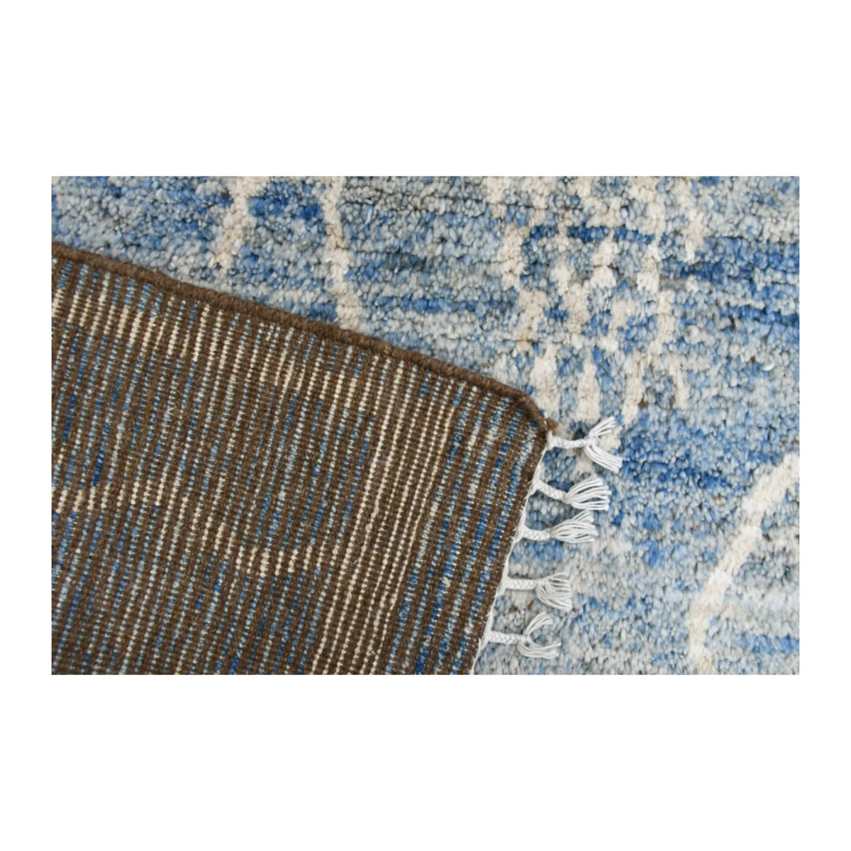 Reverse-weave detail beside the blue and ivory patterned pile of the Moroccan wool rug