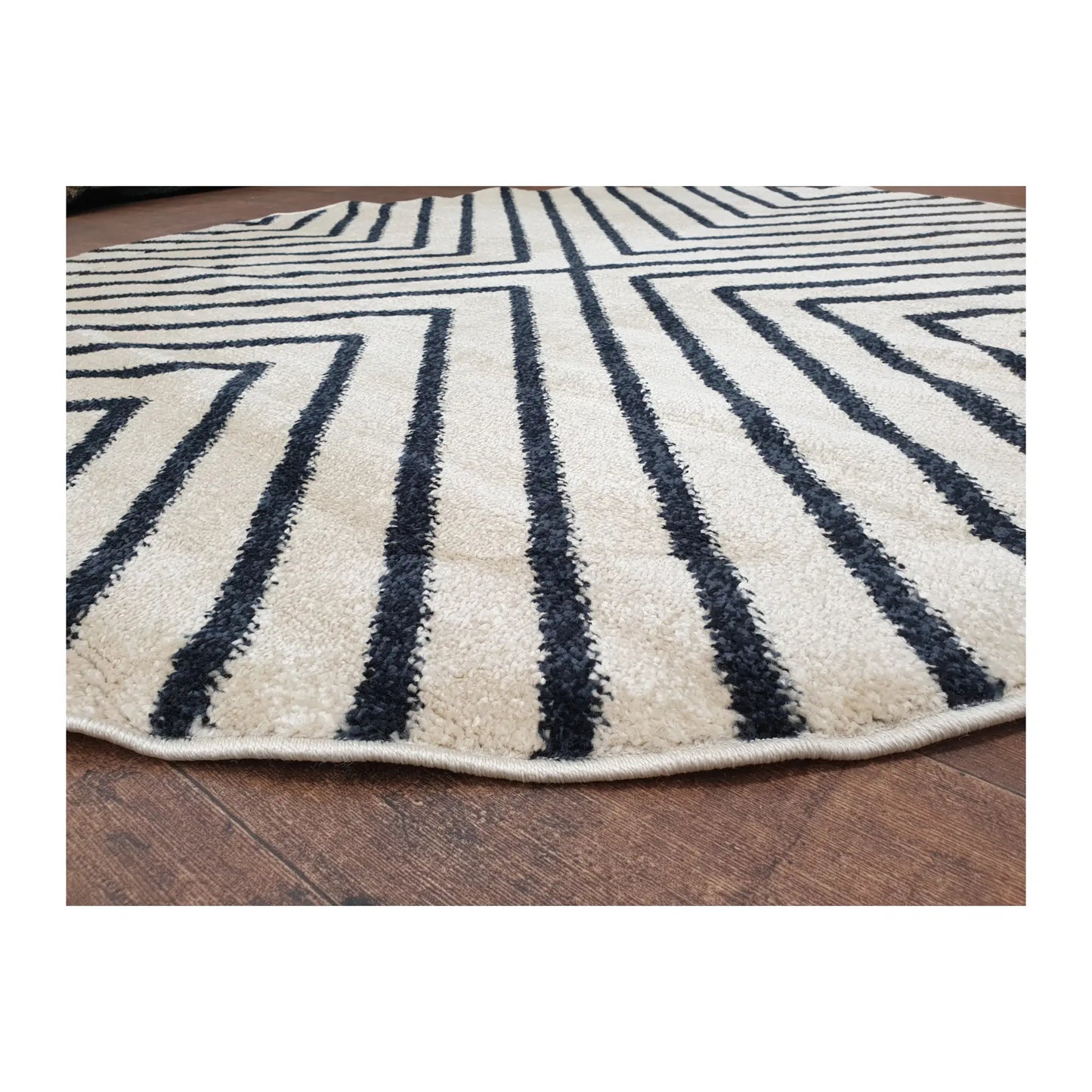 Low-angle close-up of charcoal round rug showing surface texture and diamond line design, 160 cm
