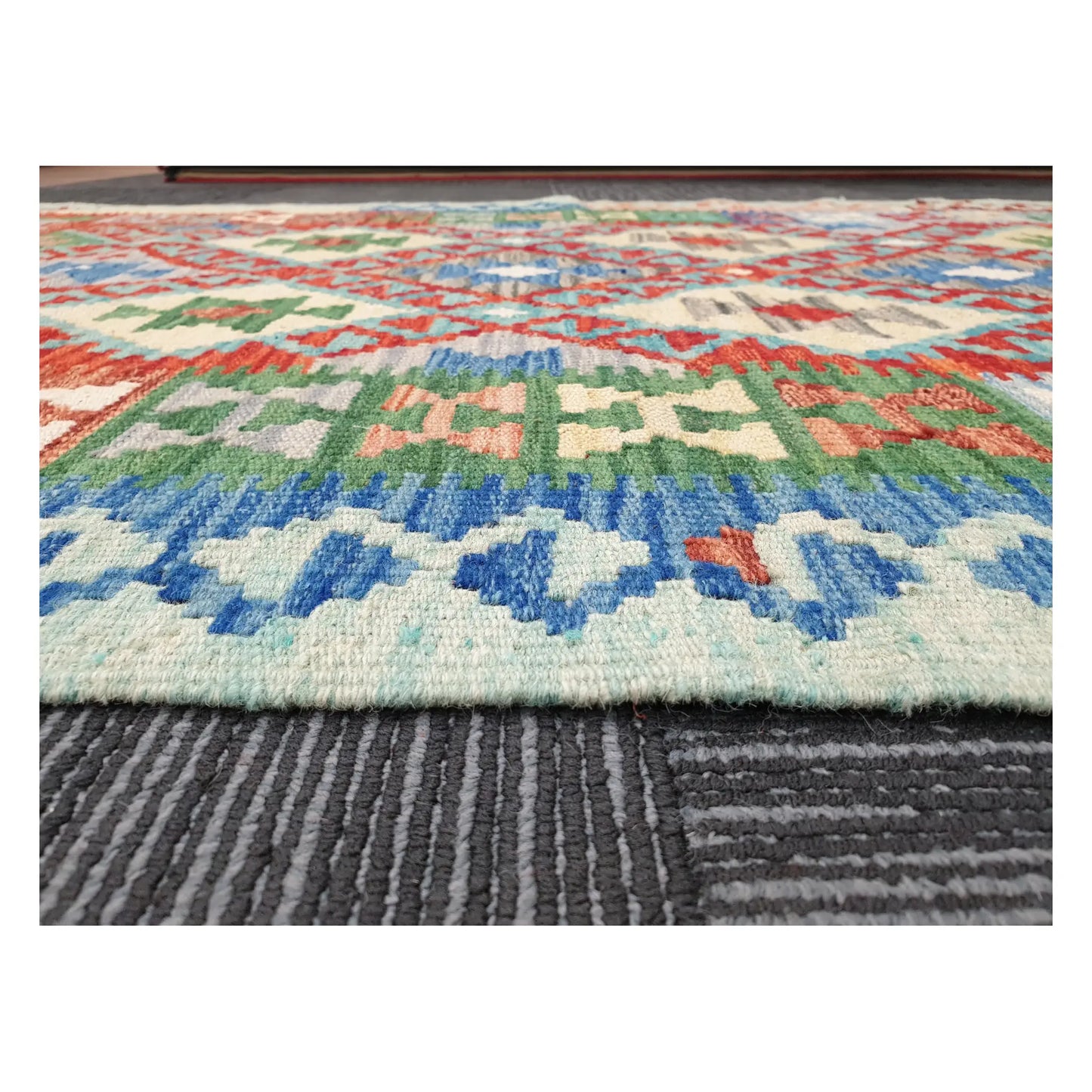 Low-angle close-up of Afghan Chobi Kilim showing wool flatweave texture and multicolour tribal pattern, 156 x 106 cm