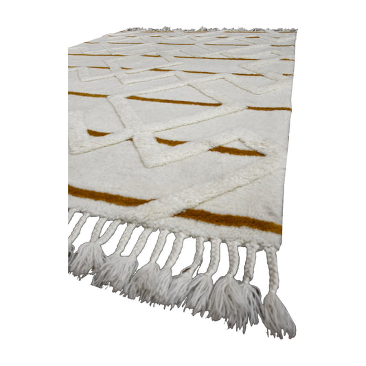 Angled view of cream and mustard hand-tufted wool rug showing its sculpted pile, geometric lines and knotted tassel fringe