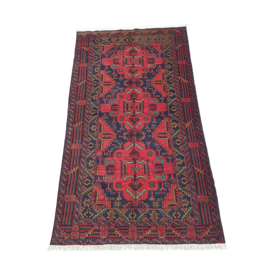 Angled full view of Afghan Baluchi wool rug with dark border and geometric motifs