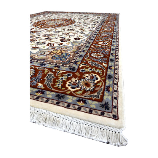 Angled view of Fine Tabriz rug showing its pale vine-patterned field, rust-red floral border and white fringe