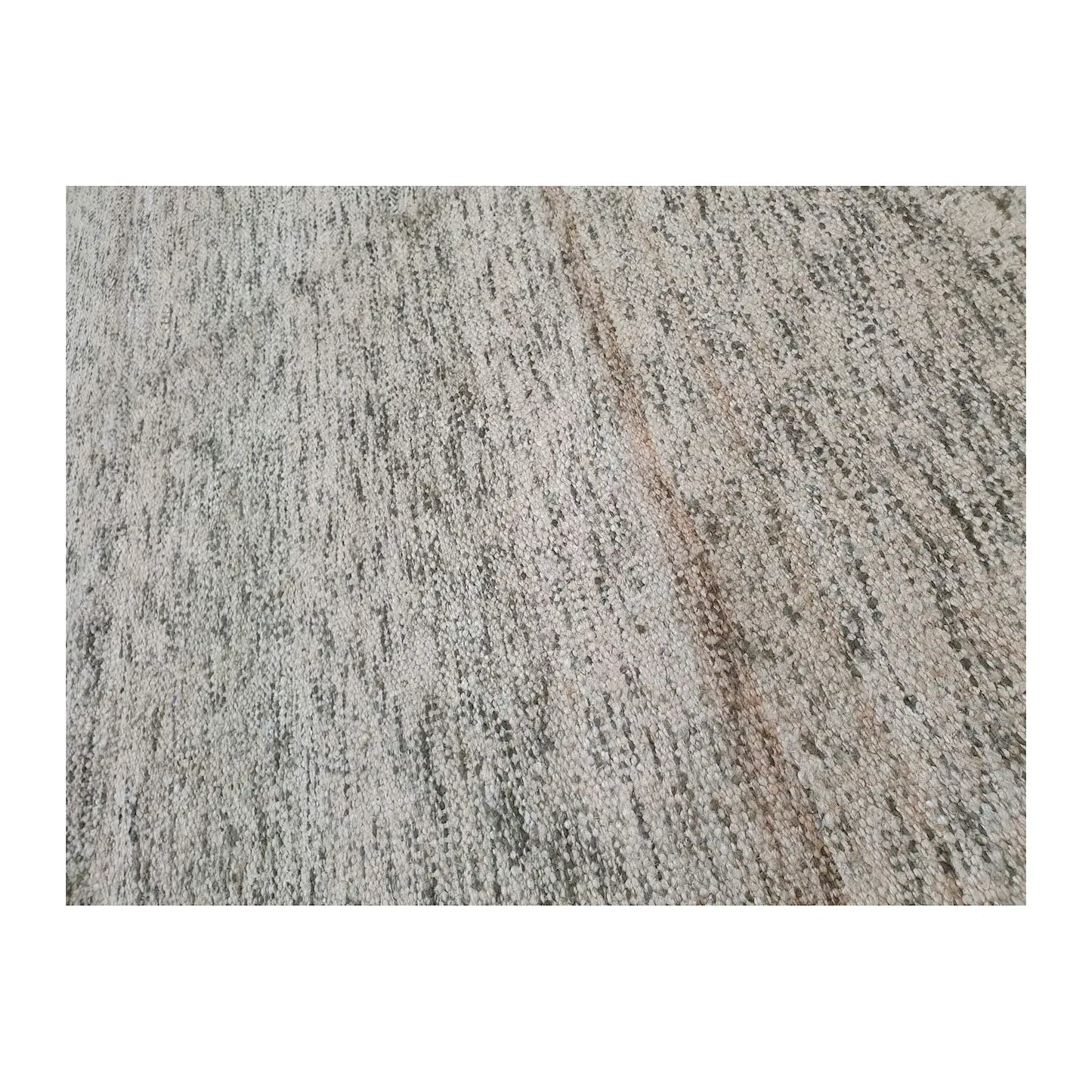 Close-up of Indian Dhurrie rug showing irregular charcoal and beige striations across an off-white woven surface