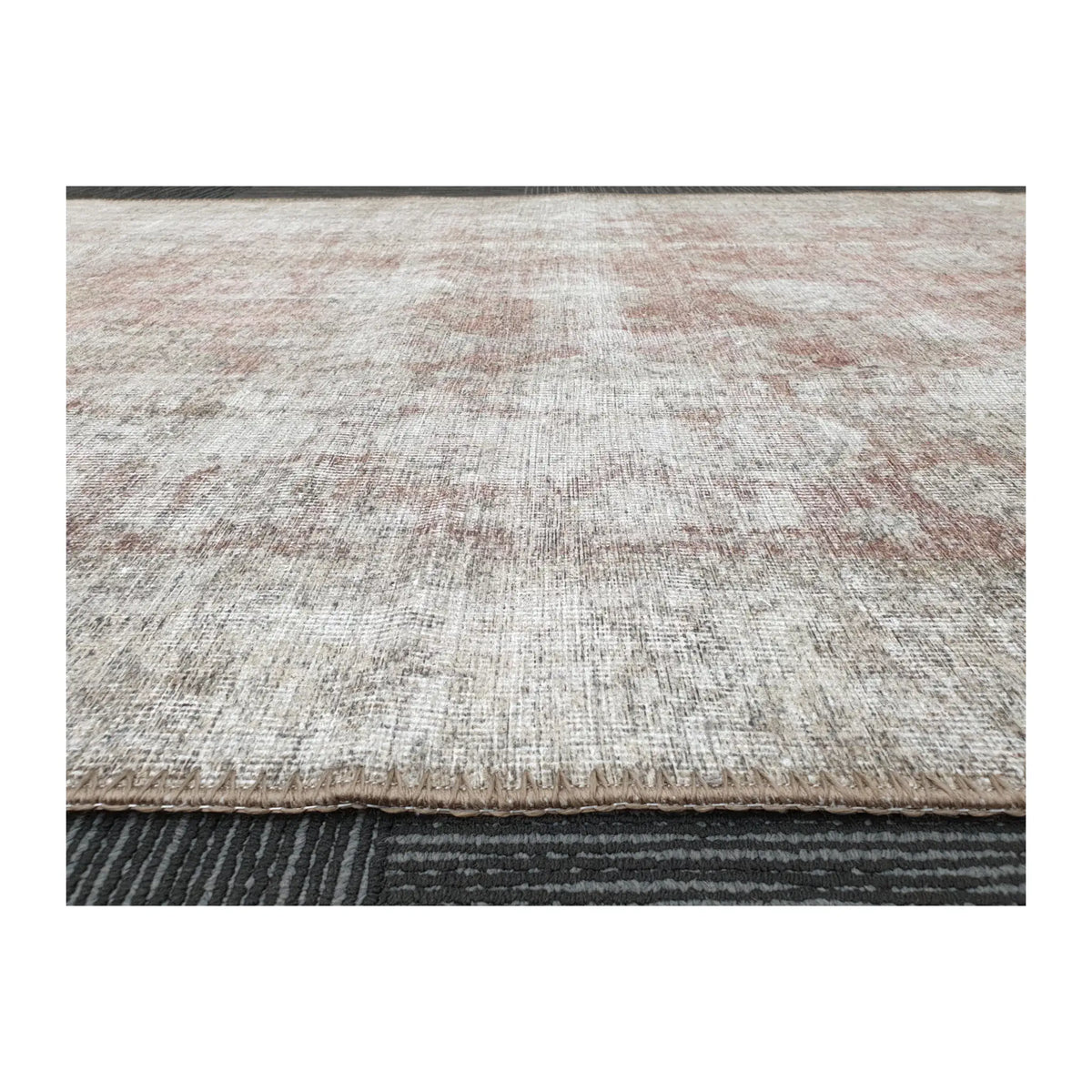Low-angle close-up of ivory blush cotton rug edge and woven surface texture
