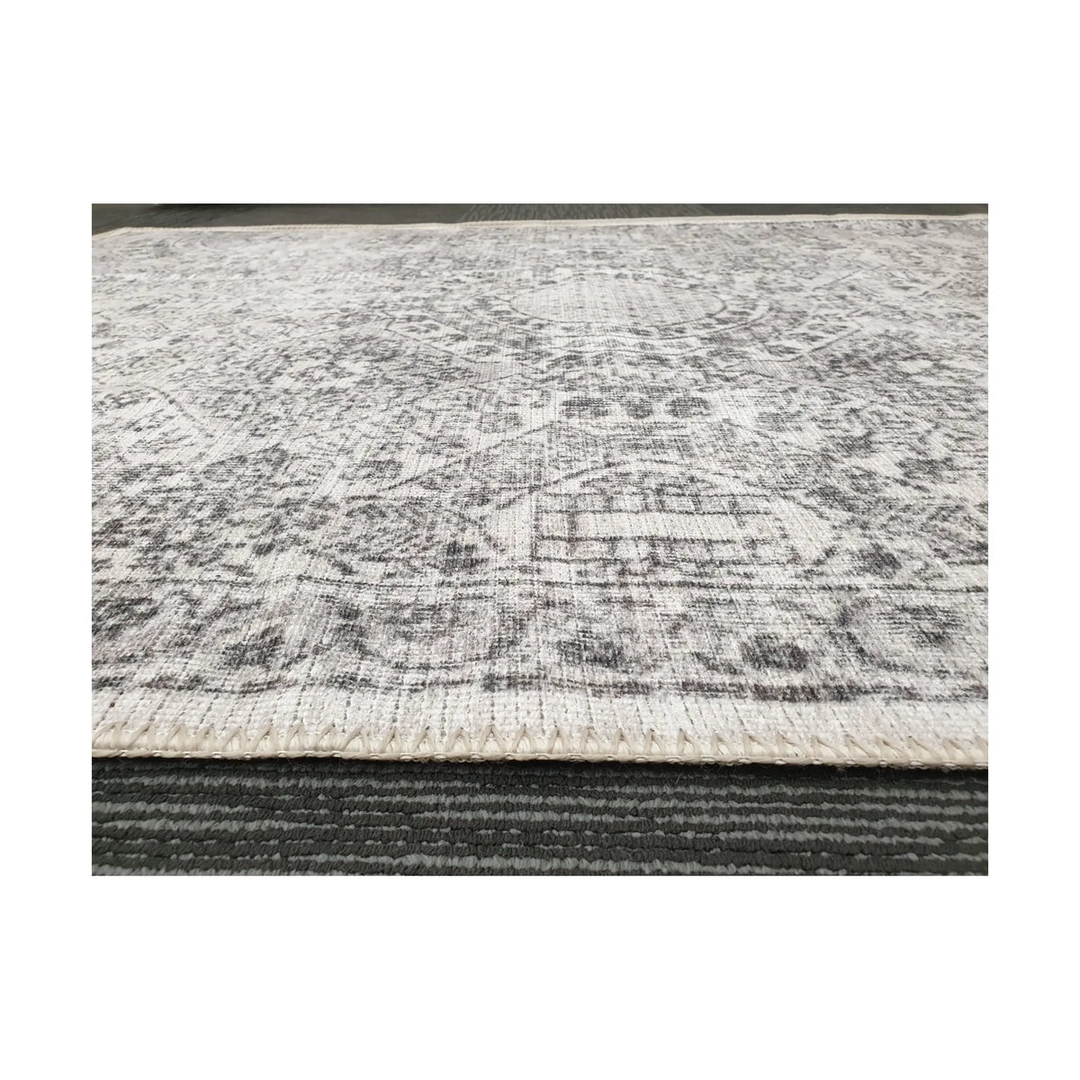 Low-angle close-up of ivory grey cotton rug edge and woven surface texture