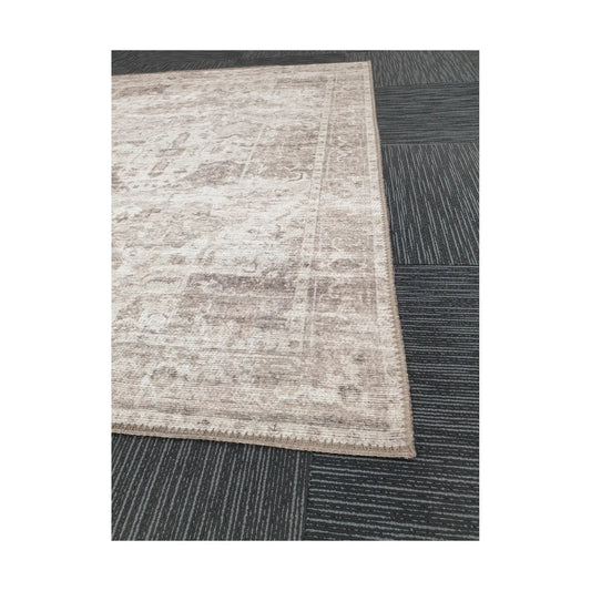 Close-up of ivory grey cotton rug corner with subtle ornamental border detail