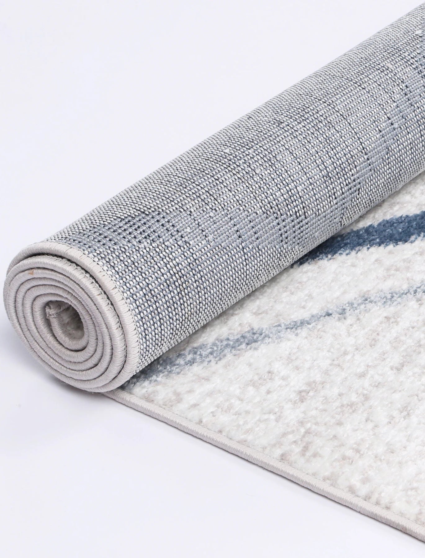 Rolled edge detail of Kimberley 2 Blue Lattice rug showing backing, binding and polypropylene pile texture, 230 x 160 cm