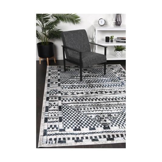 Kimberley 7 Aztec Blue rug styled with chair and indoor décor, showing modern geometric blue pattern, 230 x 160 cm