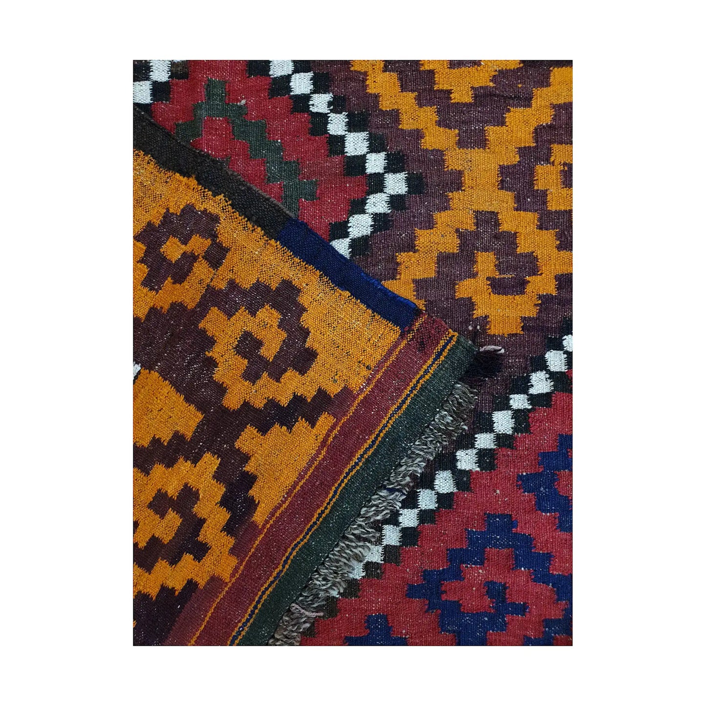 Folded corner flatweave detail of Mamina Kilim wool rug showing layered border colours and handwoven texture