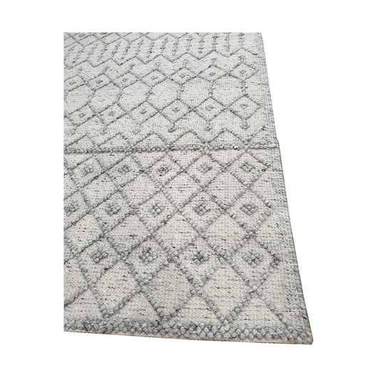 Border and edge detail of modern grey wool rug showing geometric diamond pattern and woven texture