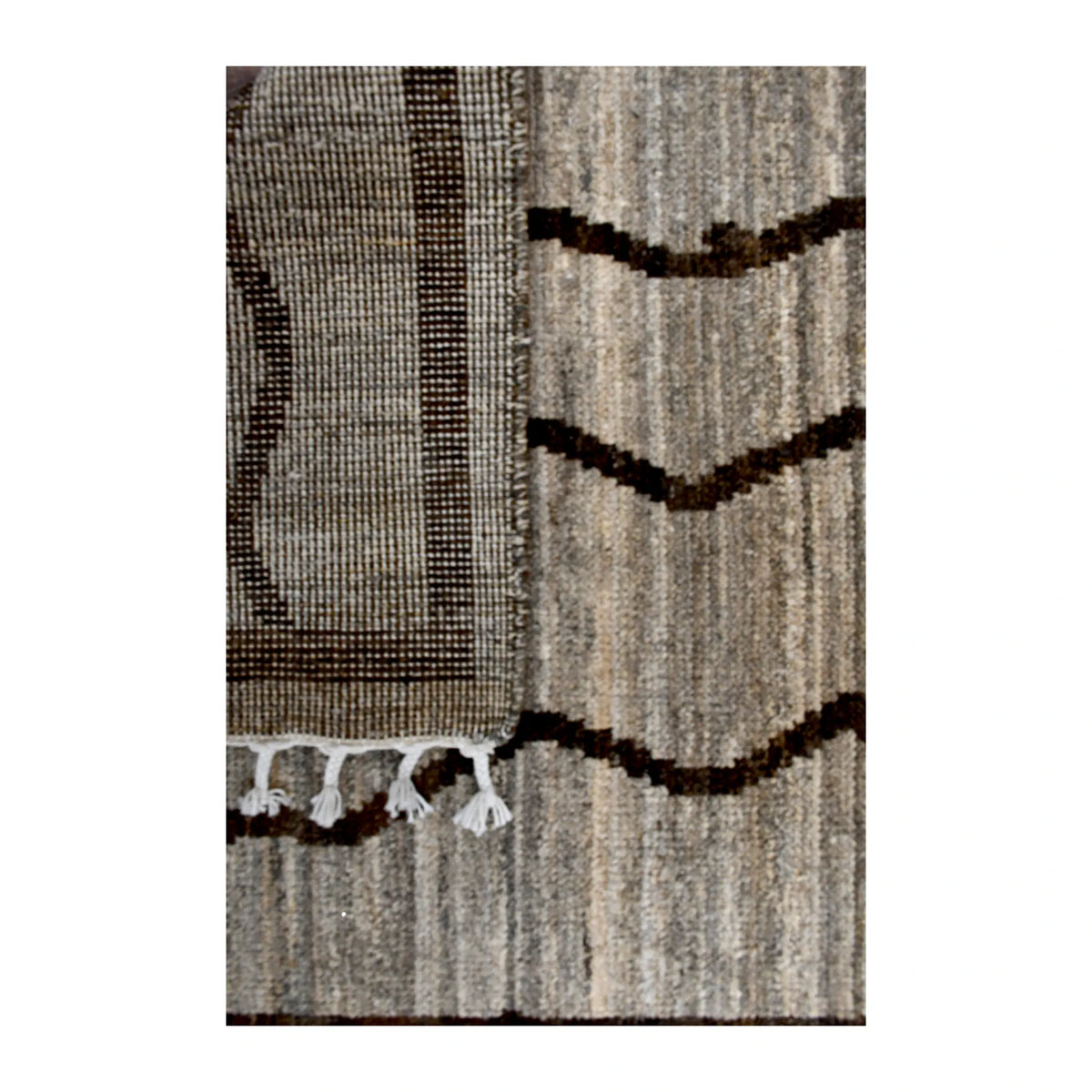 Folded-corner detail of Moroccan runner showing the reverse weave beside its beige front, dark brown linework and white tassels