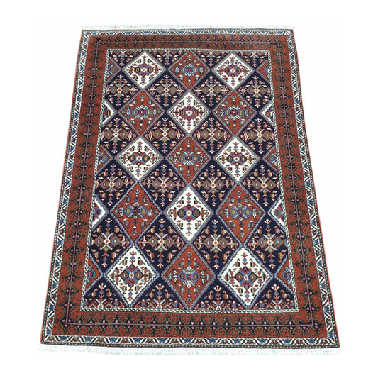 Angled full view of Persian Afshar wool rug 180 x 124 cm with tribal geometric pattern and framed border