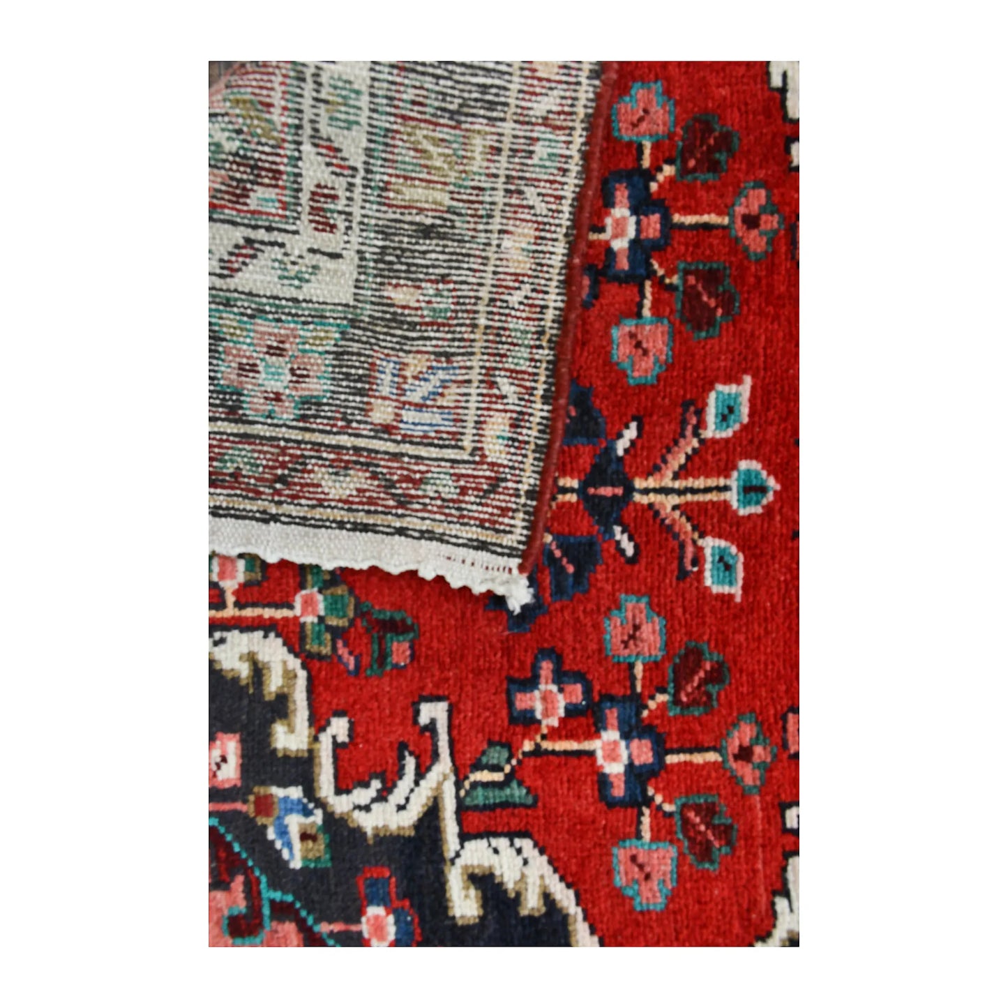 Folded corner of Persian Hamadan runner showing the patterned face, reverse weave and edge finishing