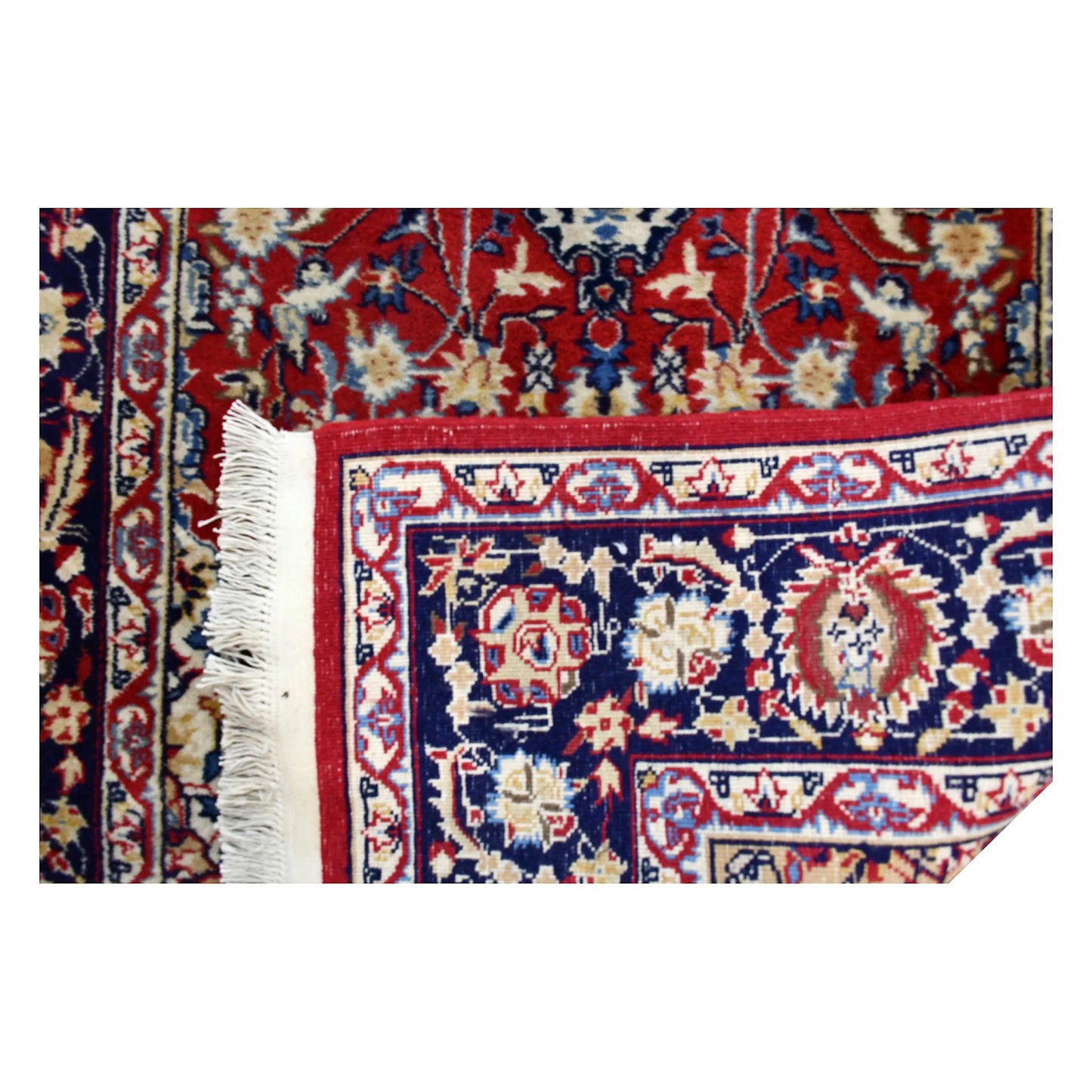 Folded corner of vintage Kashan runner showing the front wool pile, reverse weave and layered floral border